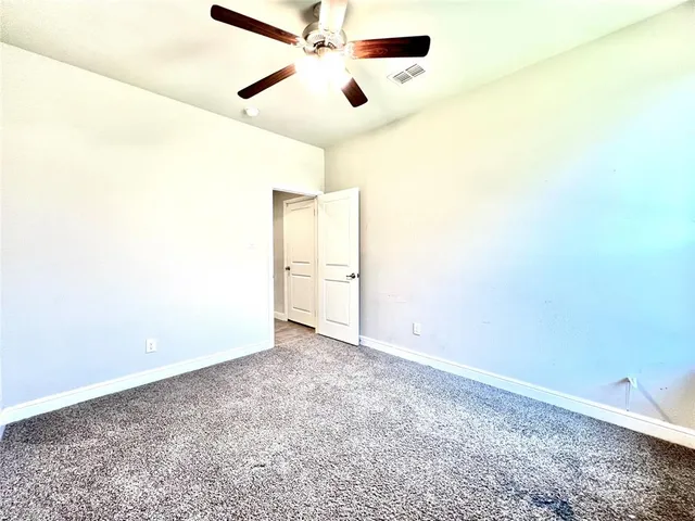 an empty room with closet and fan