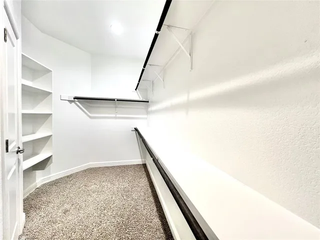 an empty room with a ceiling fan and window