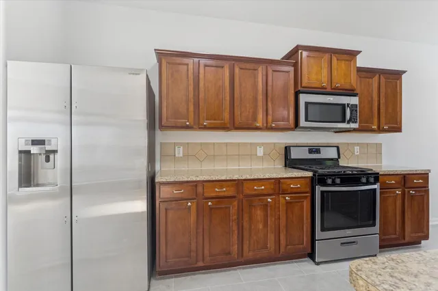 a kitchen with stainless steel appliances granite countertop a stove microwave and refrigerator
