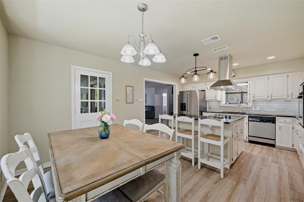 522 High Country Road Sherman, TX 75092 - Photo 14 of 38 a kitchen with stainless steel appliances kitchen island granite countertop a table chairs and a stove