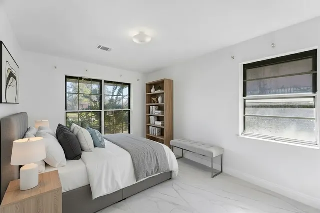 a bedroom with a bed and a large window