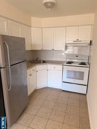 a kitchen with stainless steel appliances granite countertop a sink and a refrigerator