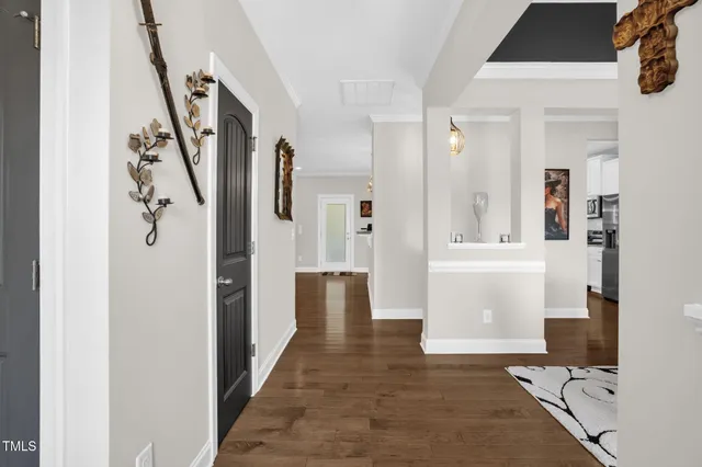 a view of a hallway with wooden floor and a living room