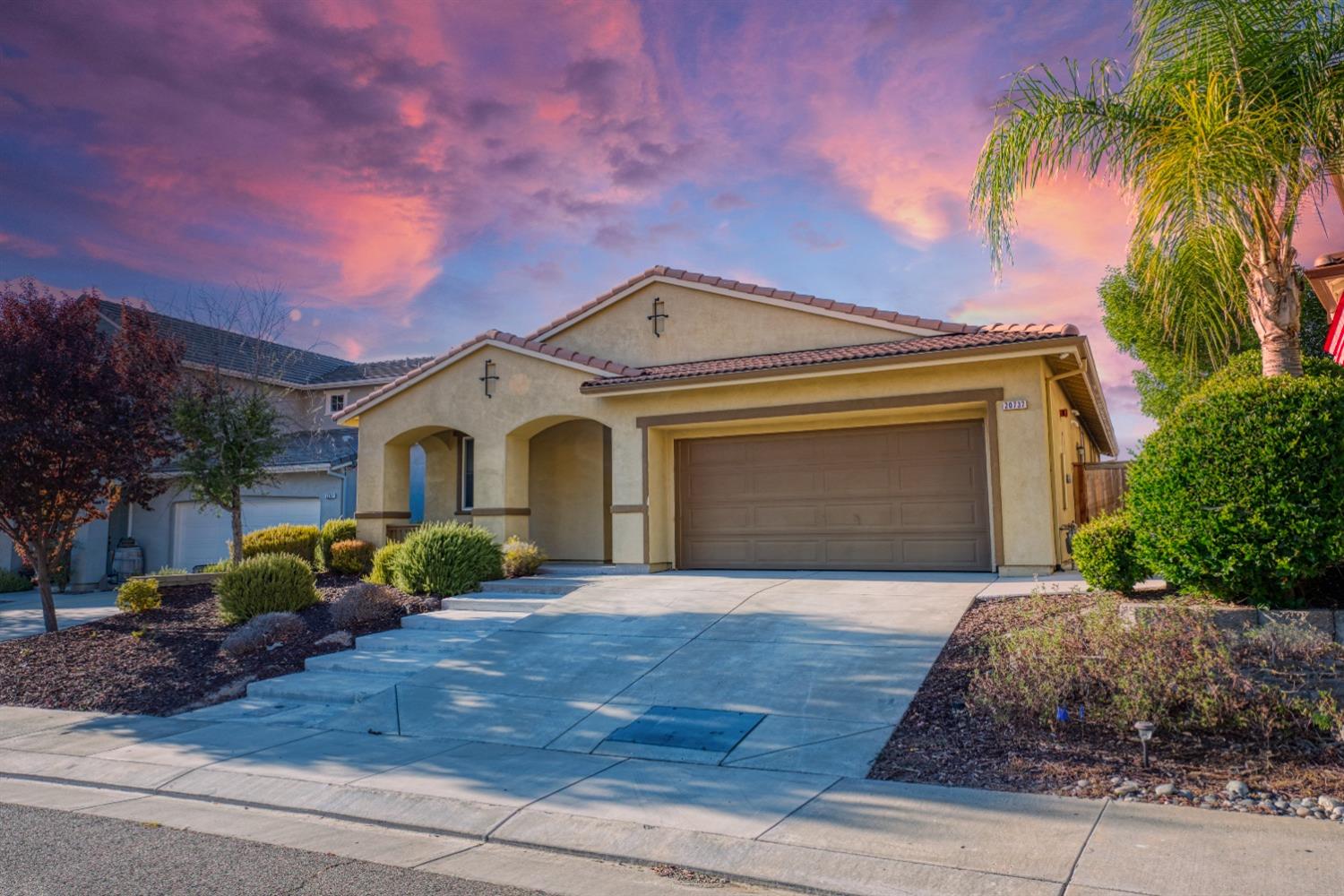 a front view of a house with a yard and garage