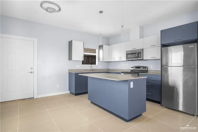 a kitchen with stainless steel appliances granite countertop a refrigerator a stove a sink and a refrigerator