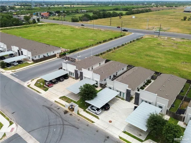 an aerial view of a residential houses with outdoor space and river