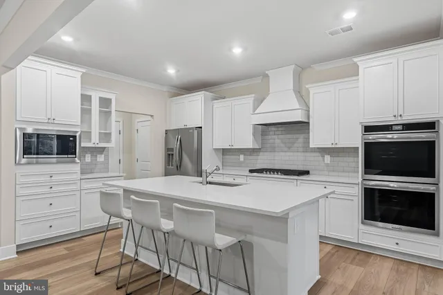 a kitchen with stainless steel appliances a stove sink microwave refrigerator and cabinets