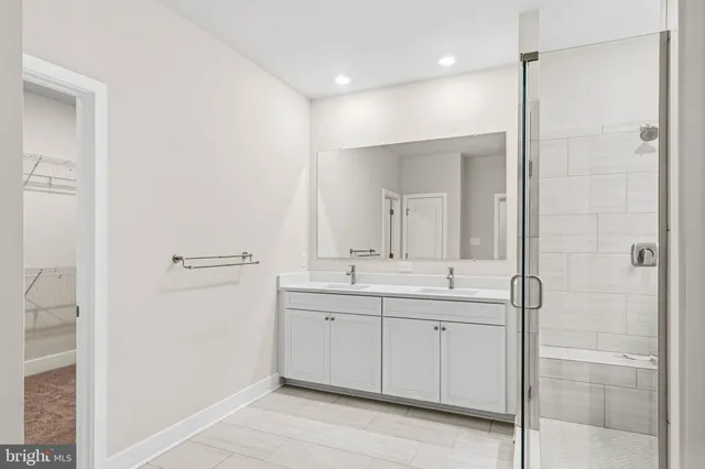 a bathroom with a double vanity sink a mirror and a shower