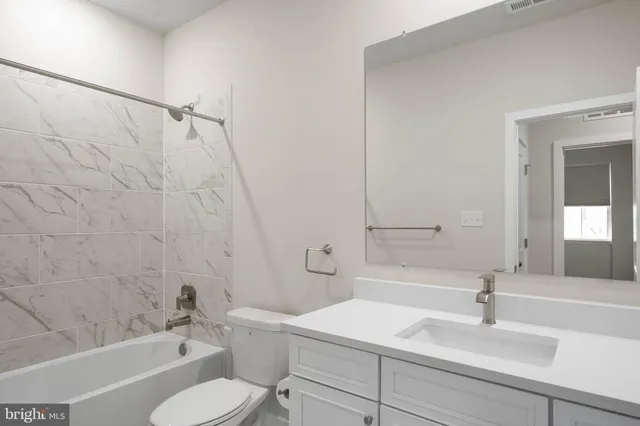 a bathroom with a sink toilet vanity and shower