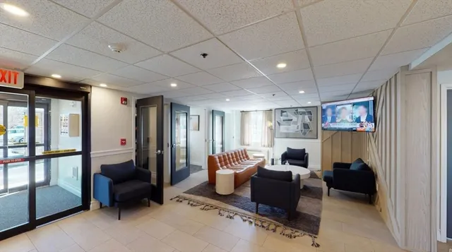 a hall with furniture and a potted plant