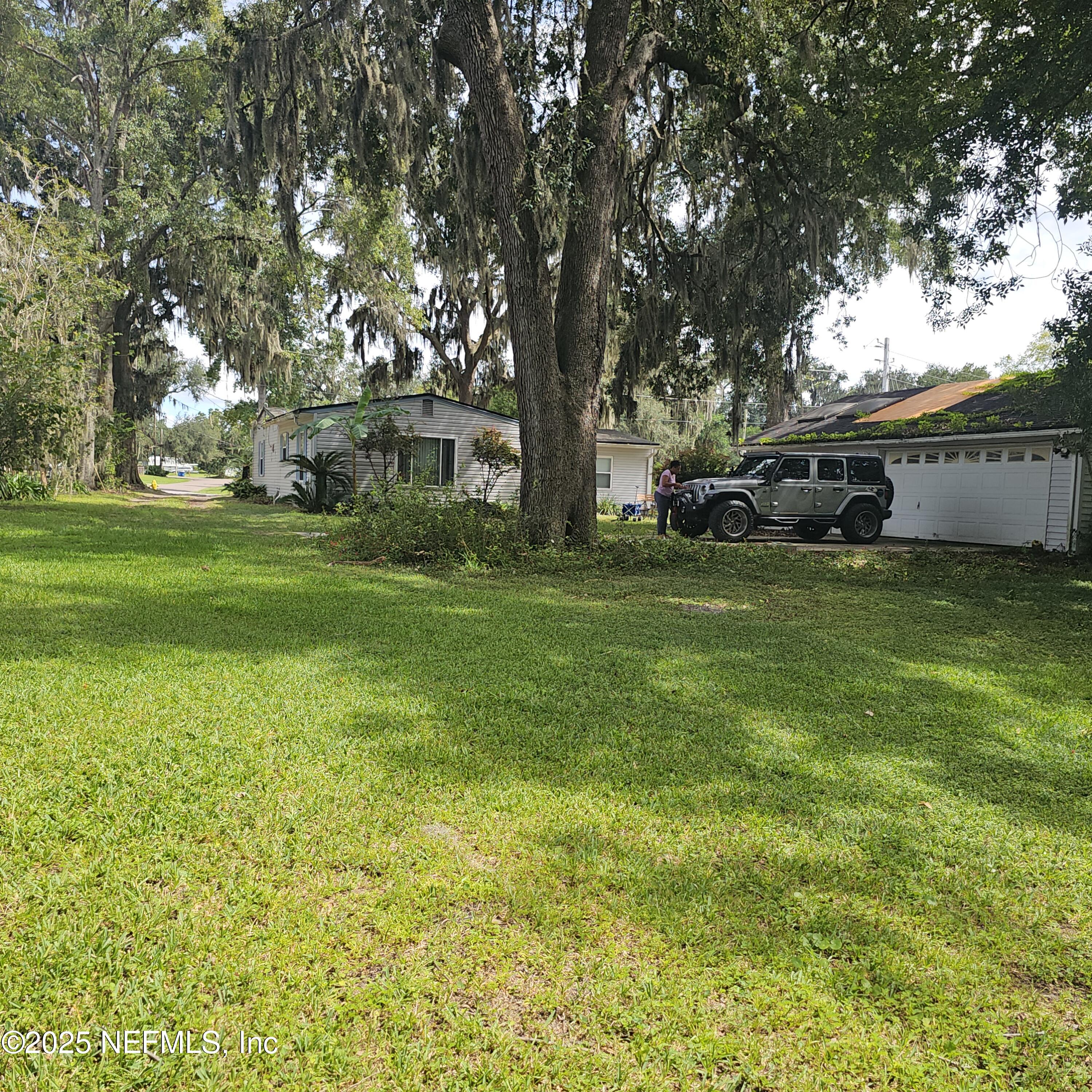 10596 Rutgers Road Jacksonville, FL 32218 - Photo 14 of 15 a view of a house with a big yard and large trees