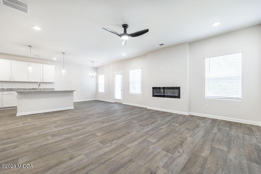 108 Cornfield Circle Perry, GA 31069 - Photo 8 of 39 a view of an empty room with wooden floor and a kitchen