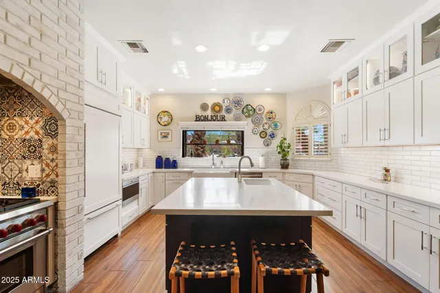 a large white kitchen with a large window