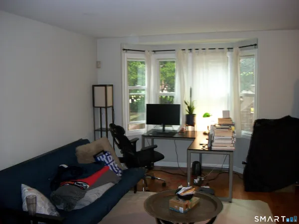 a livingroom with workspace and a couch