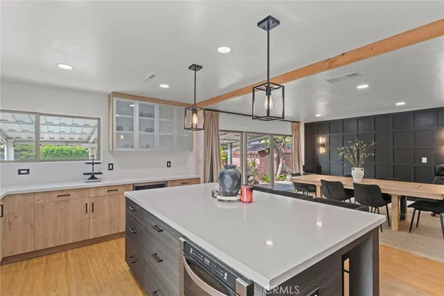 a kitchen with a stove a refrigerator a sink dishwasher with a dining table and chairs