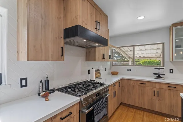 a kitchen with stainless steel appliances a sink stove and cabinets