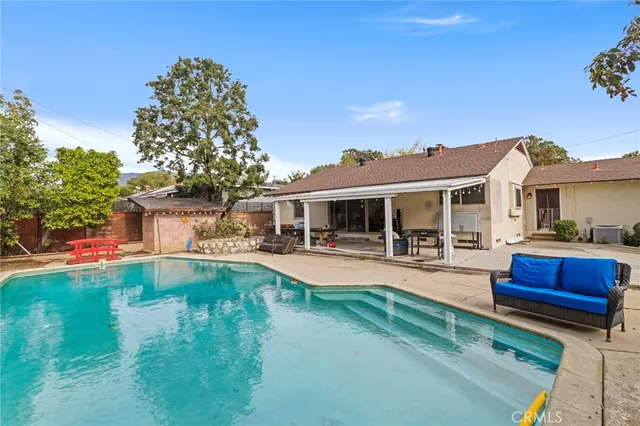 a front view of a house with swimming pool having outdoor seating