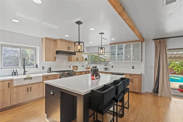 a kitchen with a sink a stove a dining table and chairs