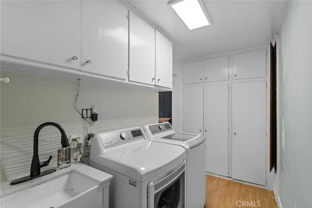 a white kitchen with sink a faucet and appliances
