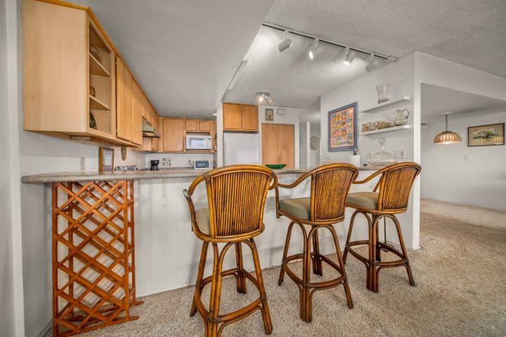 150 Puukolii Road, Unit 17 Lahaina, HI 96761 - Photo 14 of 40 a table chair sitting in a kitchen next to a window