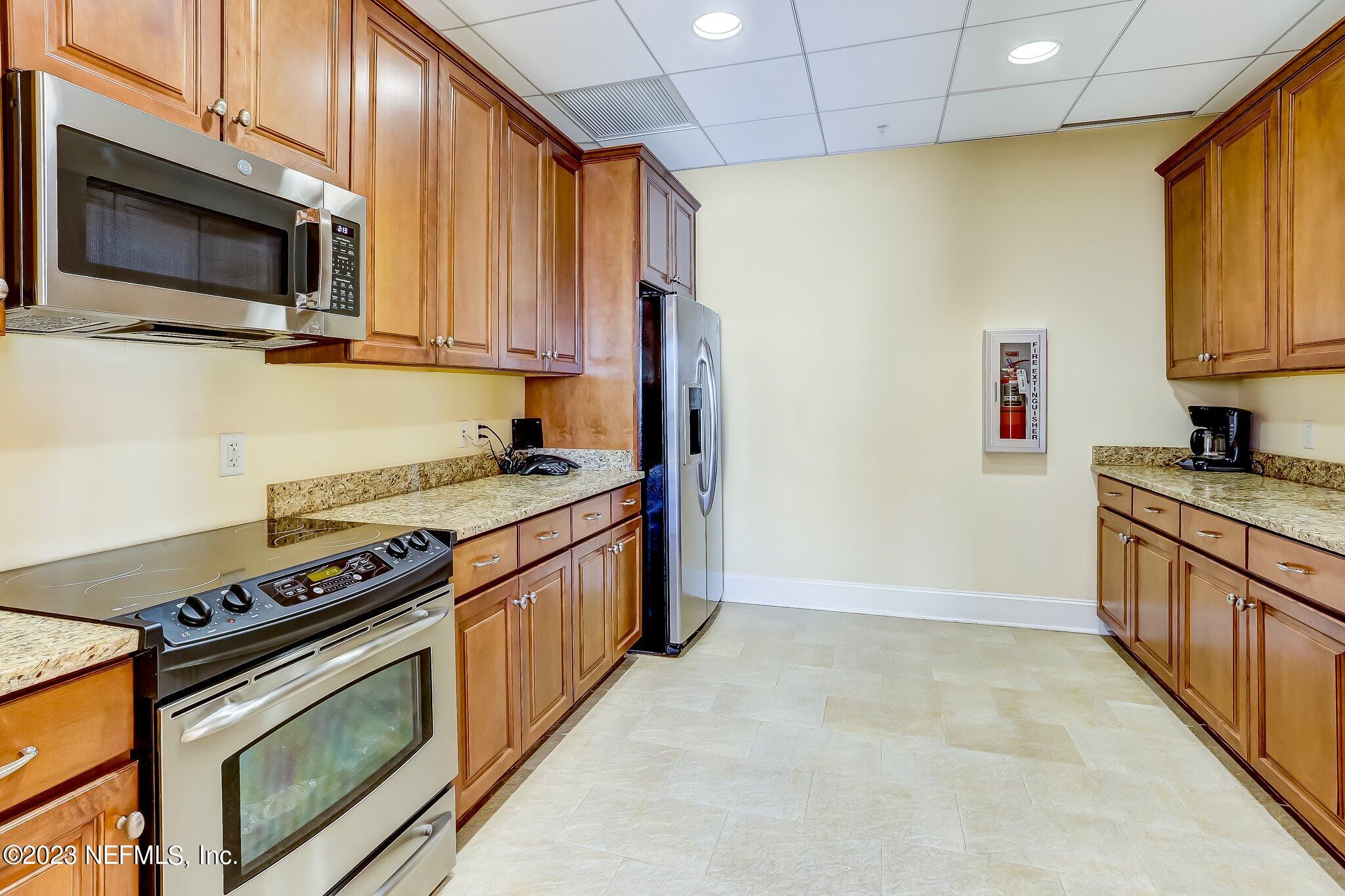 2358 Riverside Avenue, Unit 406 Jacksonville, FL 32204 - Photo 40 of 54 a kitchen with stainless steel appliances a stove a microwave sink and cabinets