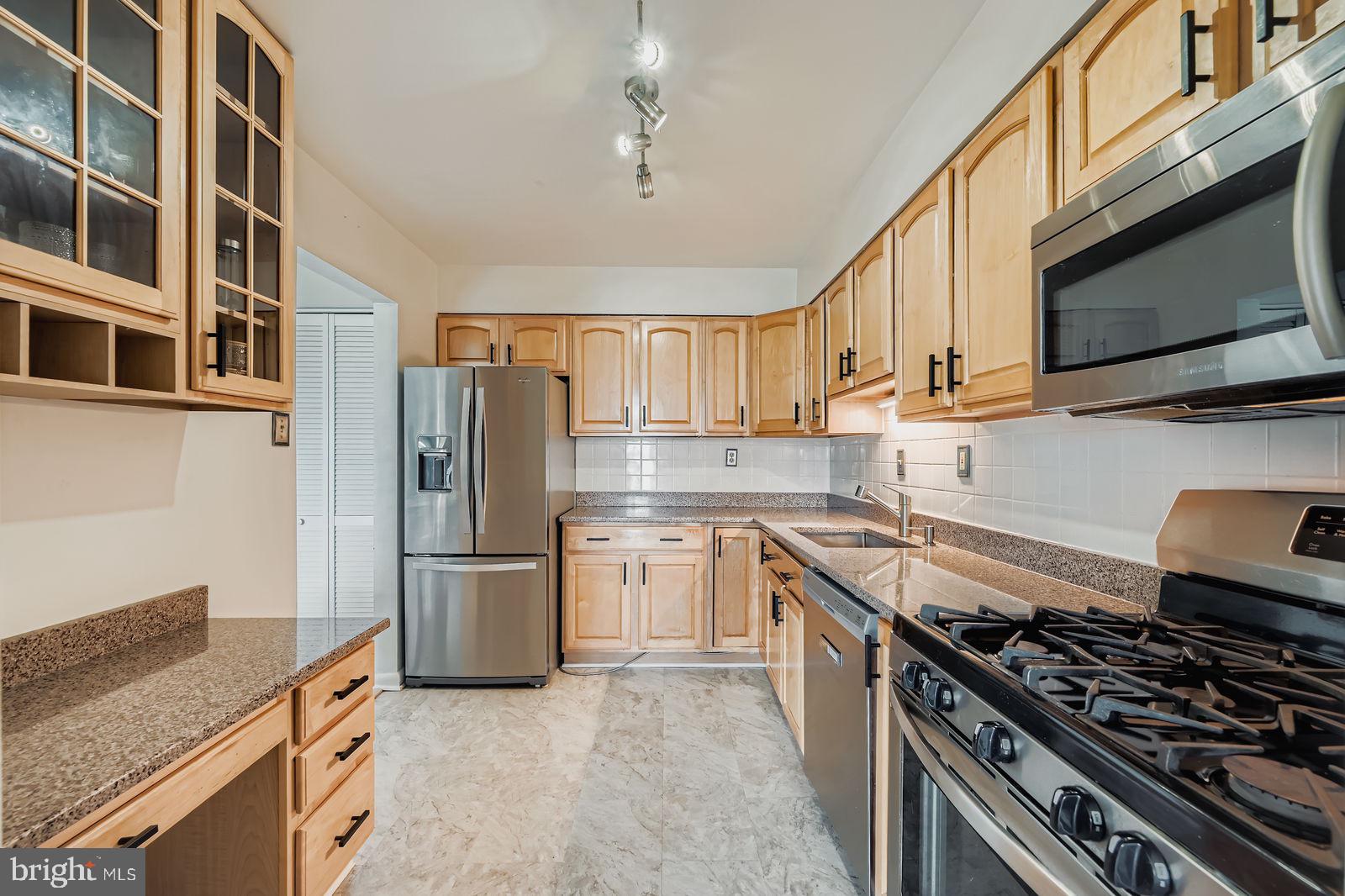9900 Georgia Avenue, Unit 27716 Silver Spring, MD 20902 - Photo 12 of 37 a kitchen with stainless steel appliances granite countertop a stove a sink and a refrigerator