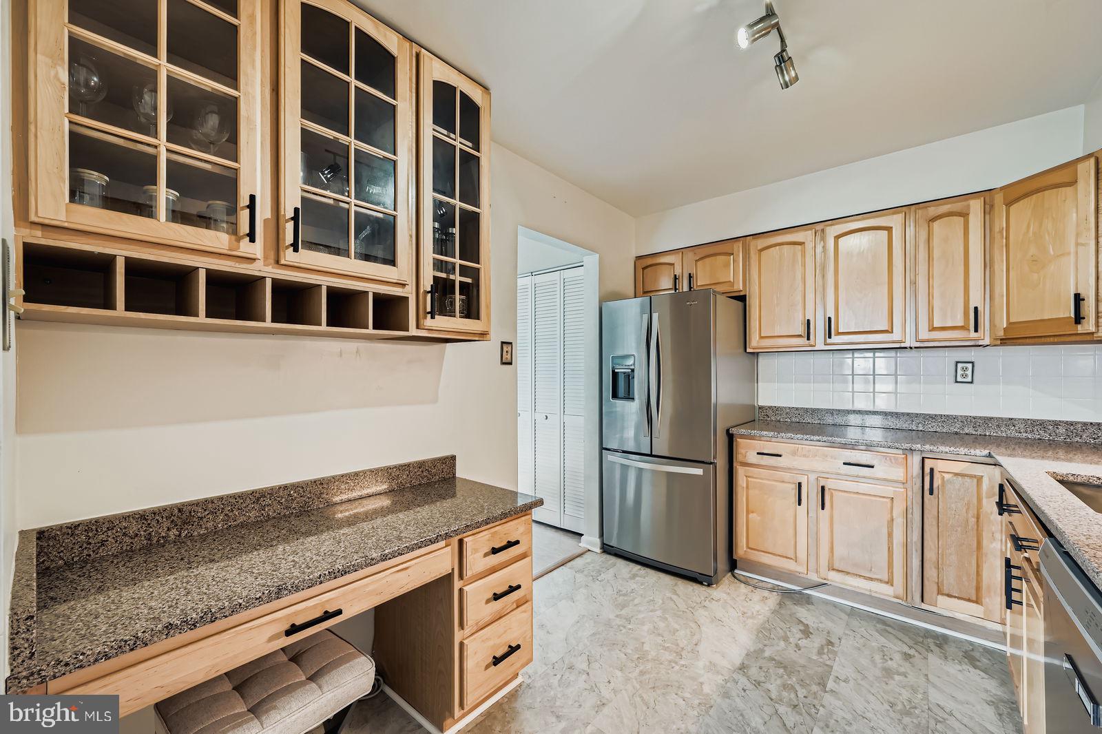 9900 Georgia Avenue, Unit 27716 Silver Spring, MD 20902 - Photo 13 of 37 a kitchen with stainless steel appliances granite countertop a refrigerator and cabinets