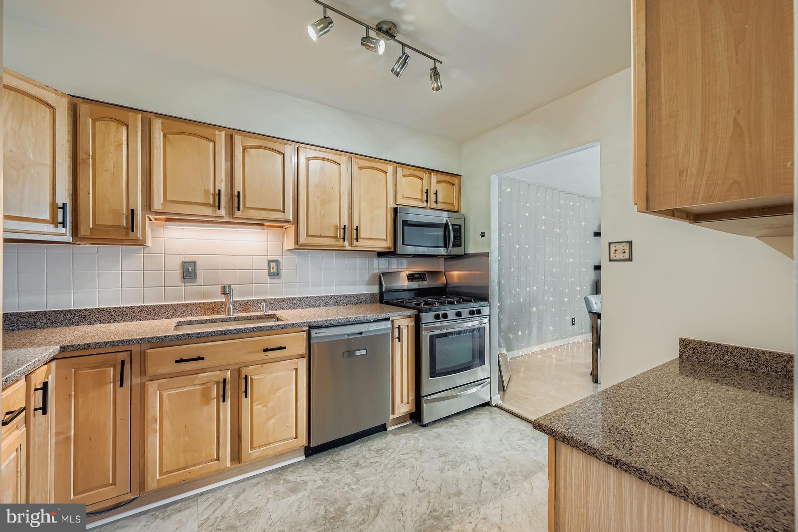 9900 Georgia Avenue, Unit 27716 Silver Spring, MD 20902 - Photo 15 of 37 a kitchen with cabinets appliances a sink and a counter top space