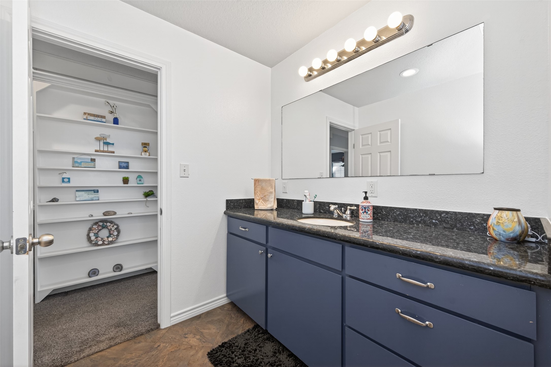 1127 County Road 299 Sargent, TX 77414 - Photo 23 of 46 a bathroom with a granite countertop sink and a mirror