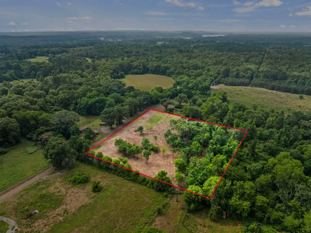 an aerial view of a house with a yard and lake view