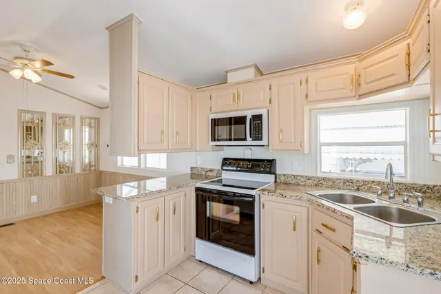 a kitchen with granite countertop a stove top oven sink and cabinets