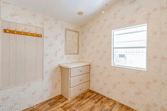 a view of a bedroom with wooden floor