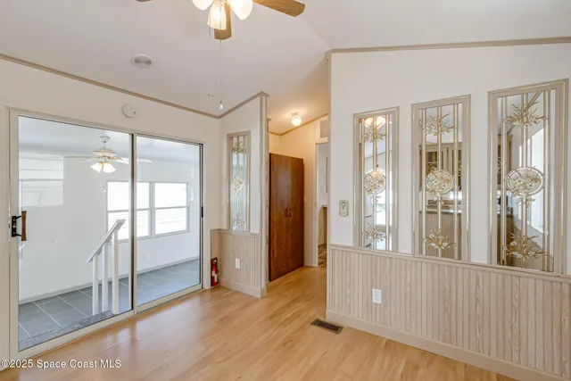 a view of a hallway with wooden floor and front door