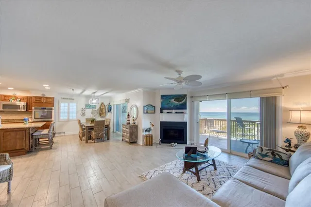 a living room with furniture kitchen view and a fireplace