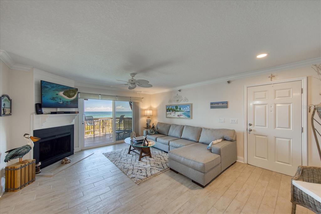 19930 Gulf Boulevard, Unit 5C Indian Shores, FL 33785 - Photo 14 of 55 a living room with furniture a fireplace and a flat screen tv
