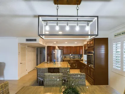 a kitchen with stainless steel appliances granite countertop table chairs and wooden floor