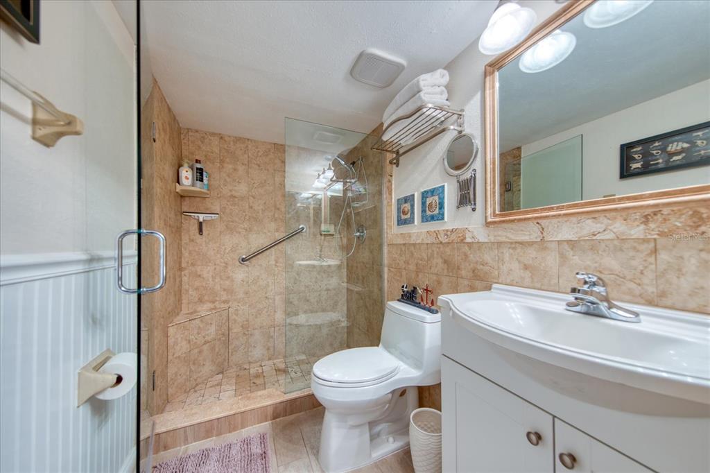 19930 Gulf Boulevard, Unit 5C Indian Shores, FL 33785 - Photo 33 of 55 a bathroom with a sink a toilet and shower