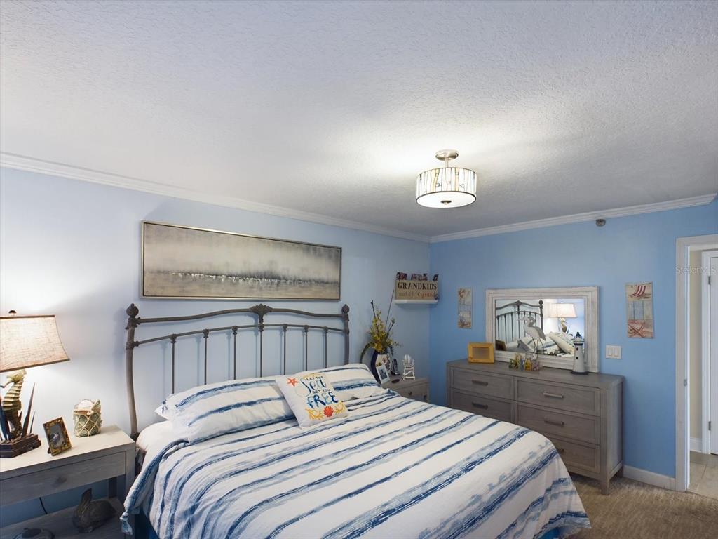 19930 Gulf Boulevard, Unit 5C Indian Shores, FL 33785 - Photo 37 of 55 a bedroom with a bed and a chandelier