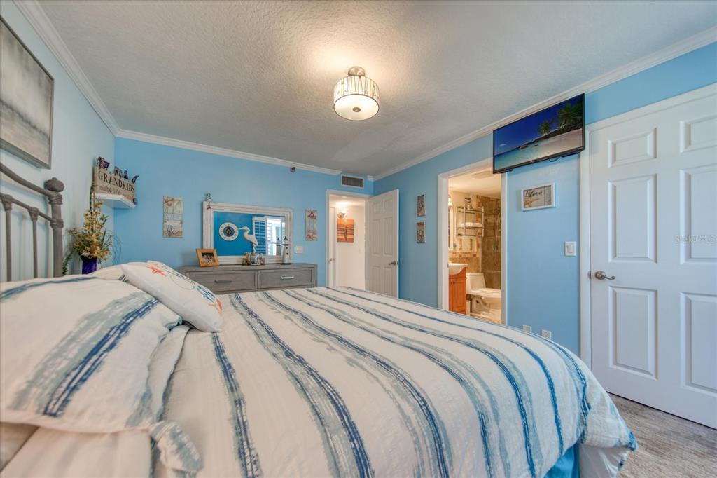 19930 Gulf Boulevard, Unit 5C Indian Shores, FL 33785 - Photo 39 of 55 a bedroom with a bed and a lamp