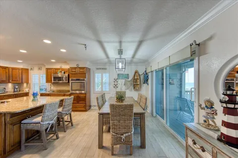 a view of a dining room with furniture a chandelier and wooden floor