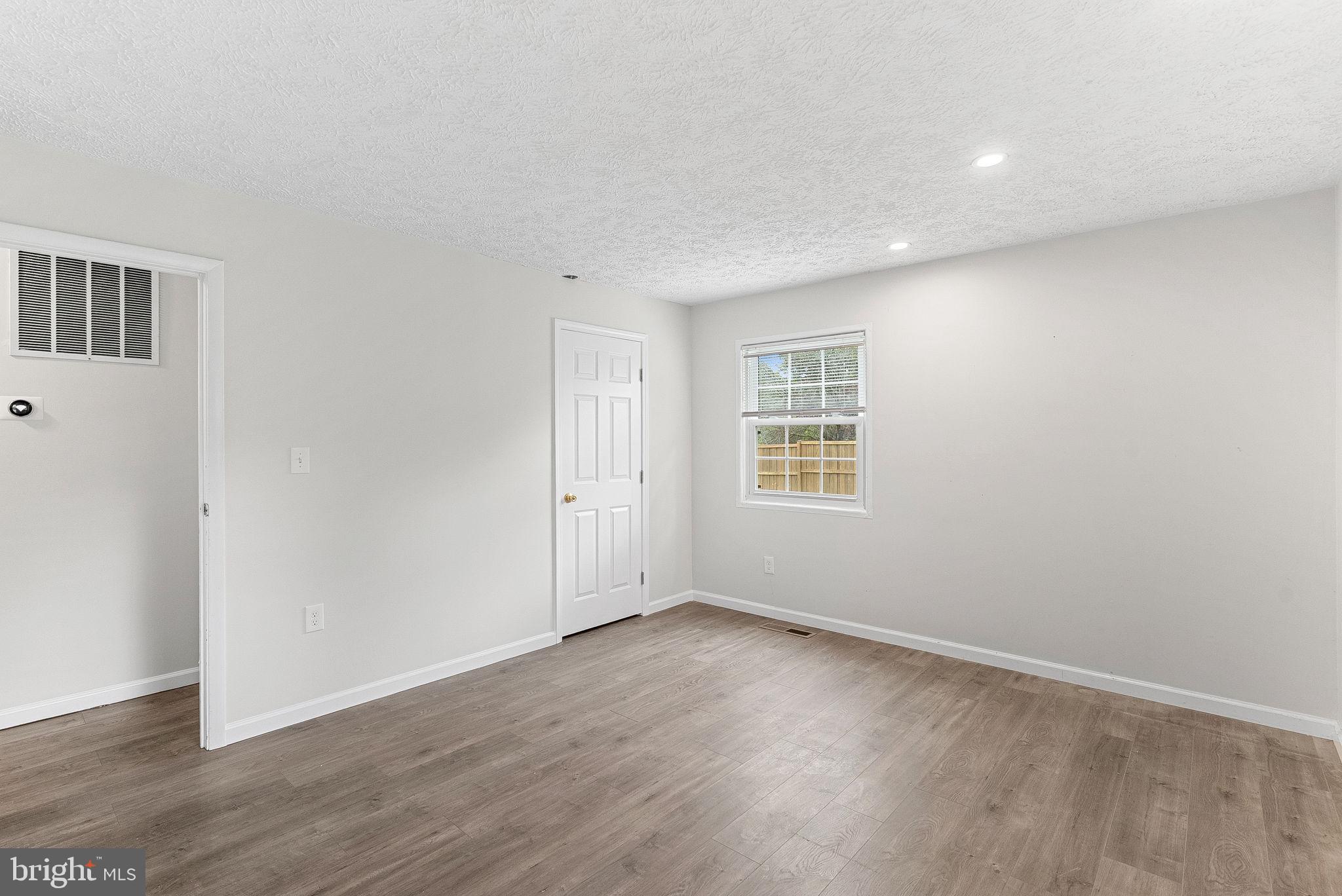 21506 Shellhorn Road Ashburn, VA 20147 - Photo 24 of 42 a view of an empty room with wooden floor and a window