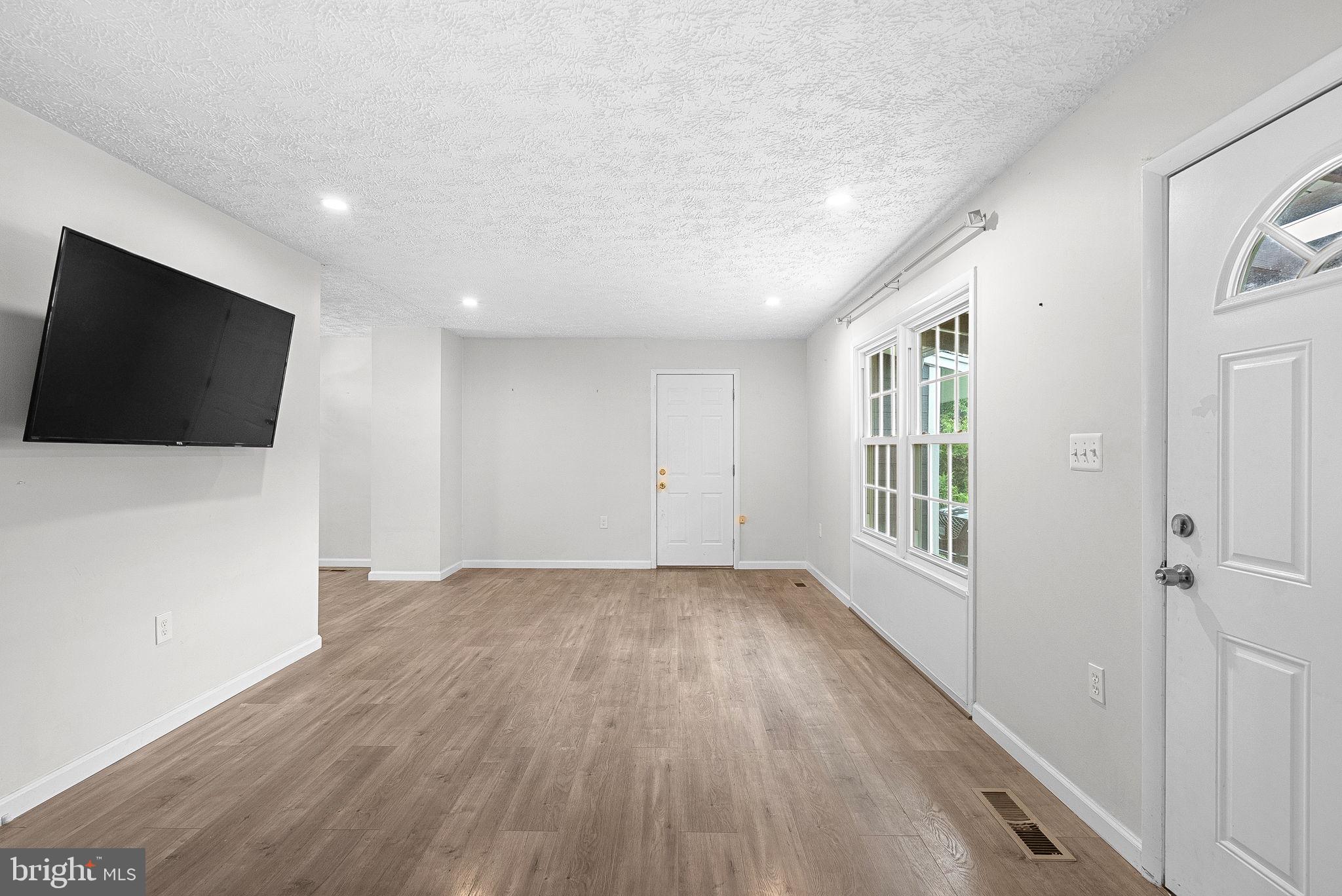 21506 Shellhorn Road Ashburn, VA 20147 - Photo 8 of 42 a view of an empty room with a window and wooden floor
