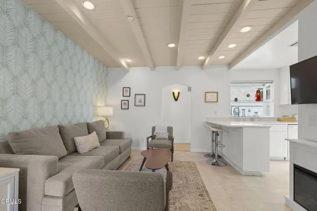 a living room with furniture and view of kitchen