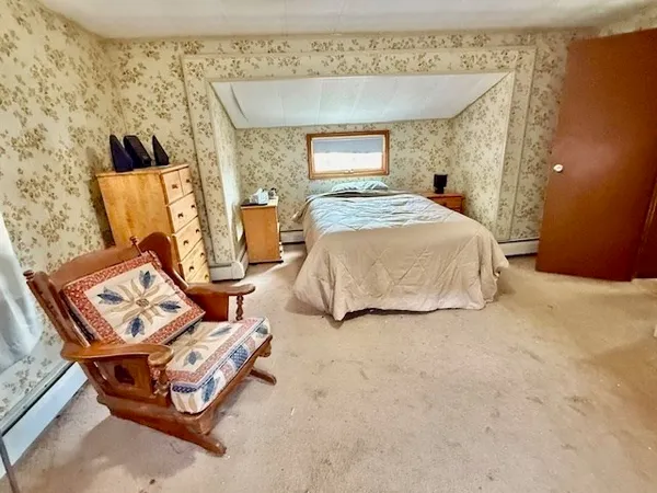 a bed room with a bed and chair