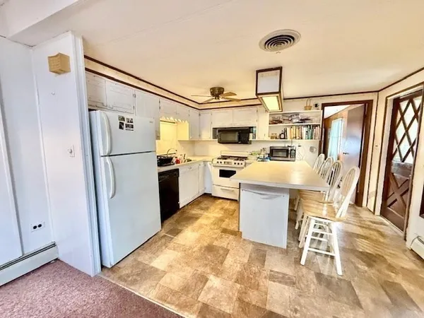 a kitchen with a refrigerator a stove top oven and a dining table