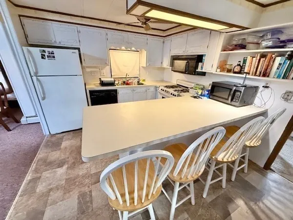 a kitchen with a table chairs refrigerator and a window