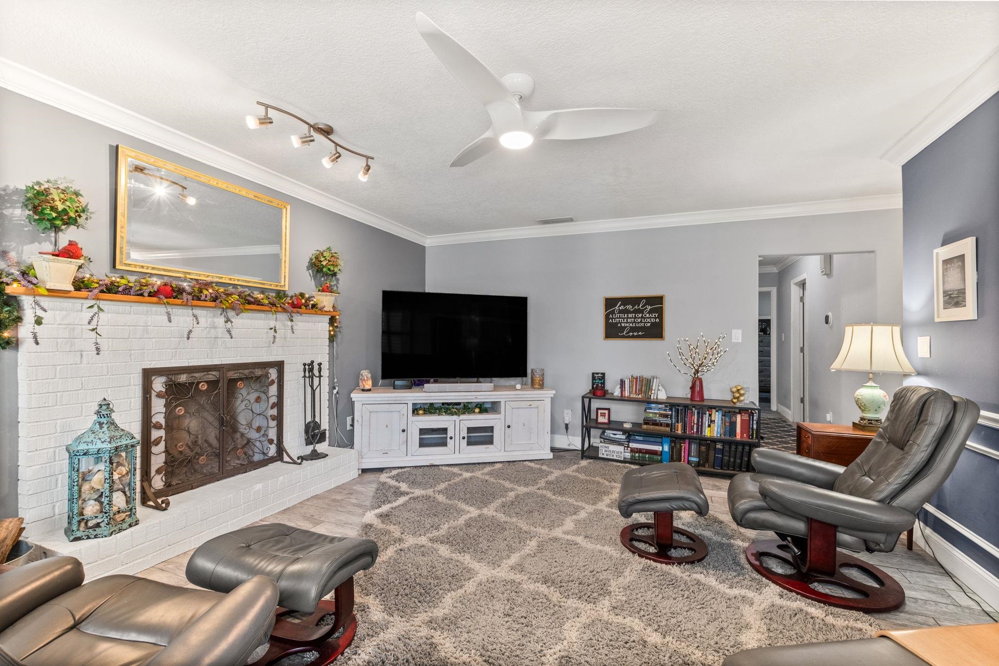 5312 Riverview Drive St. Augustine, FL 32080 - Photo 13 of 54 a living room with furniture a fireplace and a flat screen tv