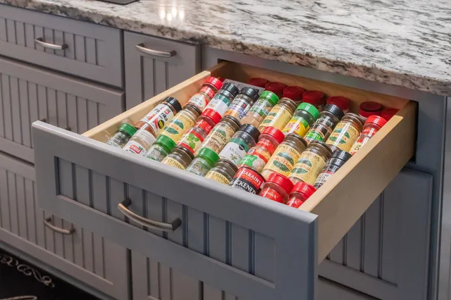 a large kitchen with stainless steel appliances kitchen island granite countertop a large stove a sink dishwasher and white cabinets with wooden floor