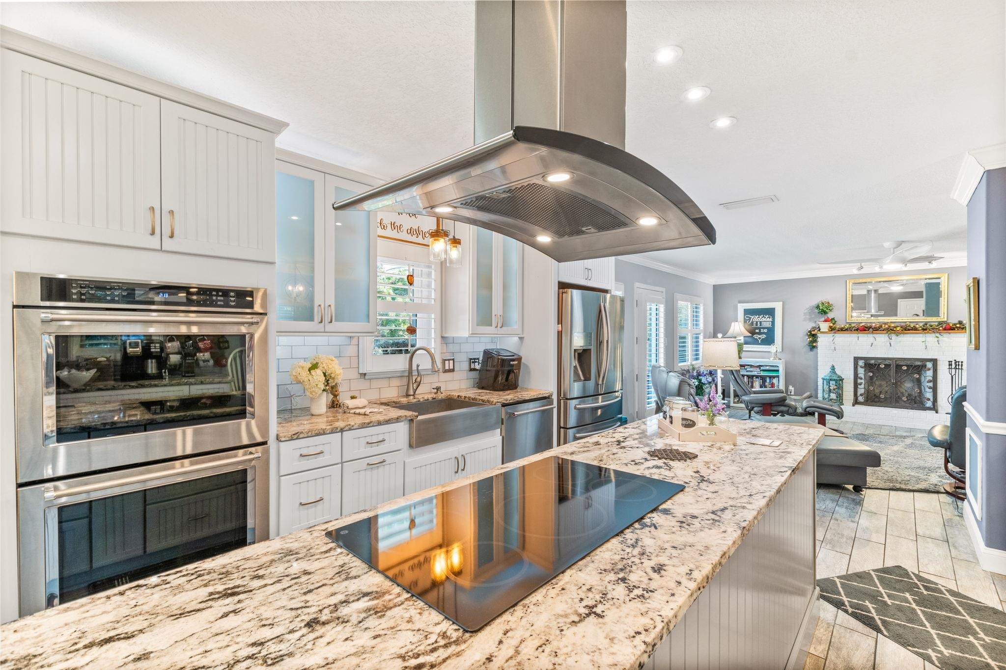 5312 Riverview Drive St. Augustine, FL 32080 - Photo 25 of 54 a large kitchen with stainless steel appliances kitchen island granite countertop a large stove a sink dishwasher and white cabinets with wooden floor
