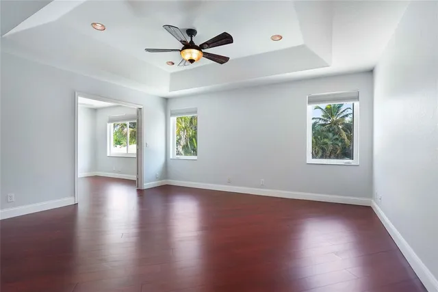 a view of a big room with wooden floor and windows
